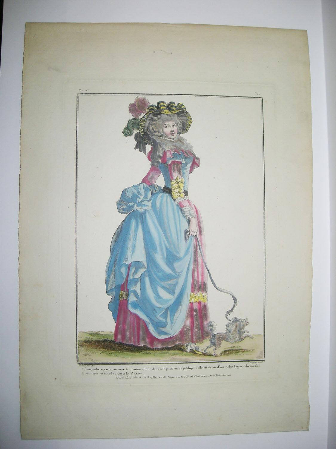 La minaudière Marinette avec son toutou chéri dans une promenade publique; elle est venue d'une robe légère du matin, la coiffure est un chapeau à la Zinzara.