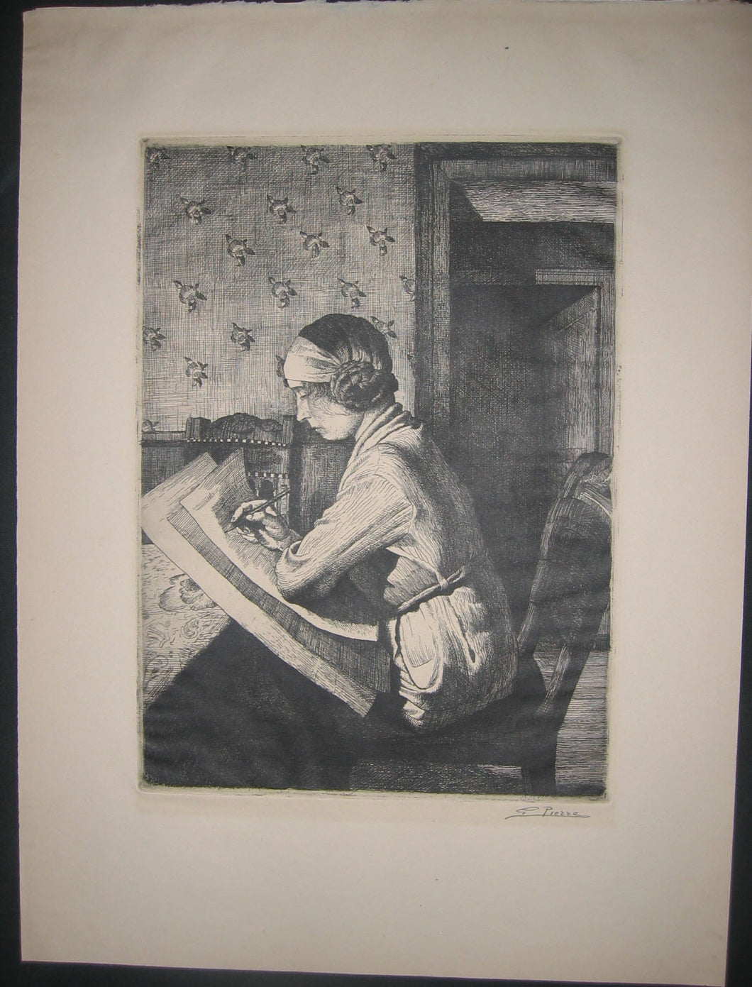 Jeune femme assise de profil, dessinant. 