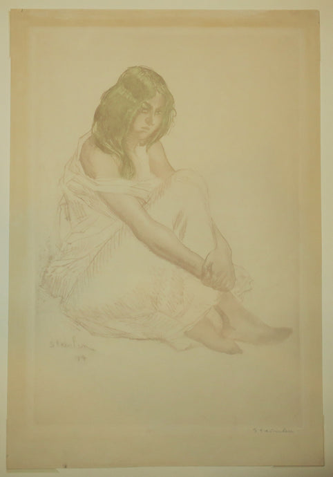 Jeune fille en robe blanche assise par terre.